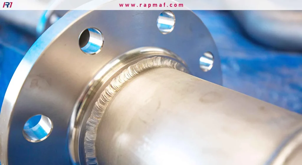 A finished TIG weld joining a pipe to a flange, showcasing the clean, precise, and uniform 'stack of dimes' appearance of the weld bead. 