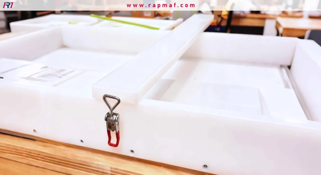A close-up of a custom-fabricated white plastic box, made from welded HDPE sheets, showing a durable stainless steel toggle latch on its side.