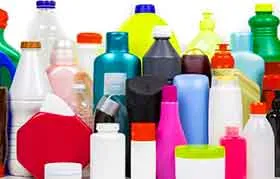 Uma grande coleção de garrafas e recipientes plásticos de consumo diário em vários formatos, tamanhos e cores, representando embalagens plásticas e reciclagem.