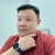 Clive Chen, a man in a red shirt, resting his chin on his hand and looking at the camera.