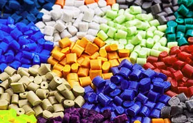 Close-up of multicolored urethane plastic granules, the base material for injection molding and urethane casting processes.