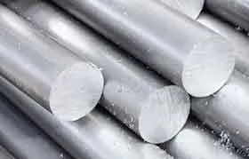 Um close de várias barras redondas de alumínio ou aço empilhadas, representando matéria-prima para usinagem e fabricação.