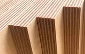 Um close-up extremo das bordas de painéis de madeira projetados alinhados verticalmente, como LVL, mostrando um padrão listrado denso criado pelas inúmeras camadas paralelas.