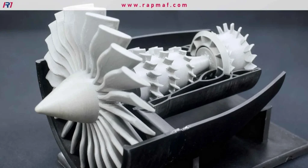 A highly detailed, 3D printed cutaway model of a jet engine, showcasing the intricate fan blades and internal turbine stages. The white model sits in a black display cradle.