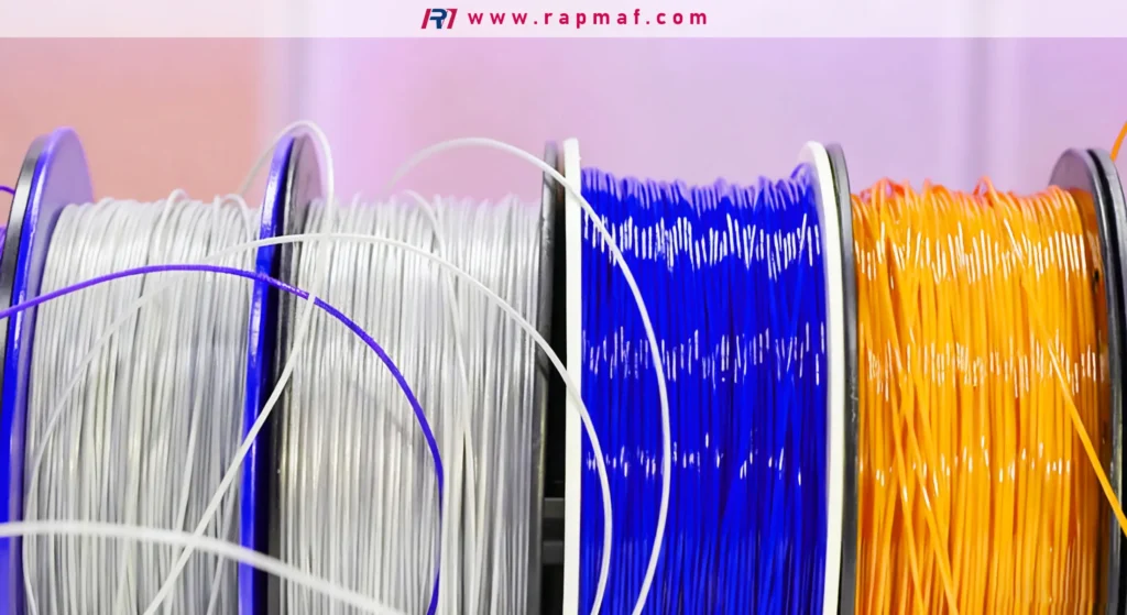 Four spools of thermoplastic filament for 3D printing in various colors, neatly wound and ready for use in an FDM machine.
