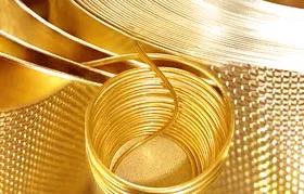 Uma imagem ampliada de produtos metálicos fabricados, incluindo uma bobina de fio de latão e rolos de chapa metálica estampada, demonstrando a conformabilidade dos metais para uso industrial.
