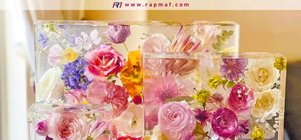 Several clear, polished resin blocks of different sizes containing beautifully preserved flowers, showcasing an artistic use of clear casting epoxy or polyester resin.