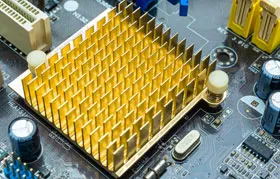 Um exemplo de solução de resfriamento passivo: um dissipador de calor com aletas douradas acoplado a um circuito integrado em uma placa-mãe verde. Ele funciona transferindo o calor do chip para o ar circundante.