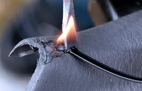 The process of thermal plastic welding, showing a concentrated heat source melting a filler rod to create a permanent bond with the base polymer material, demonstrating a common repair technique.