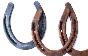 Uma representação visual da oxidação em metal ferroso, contrastando uma ferradura nova e não corroída com uma velha e muito enferrujada para explicar o conceito de ferrugem.