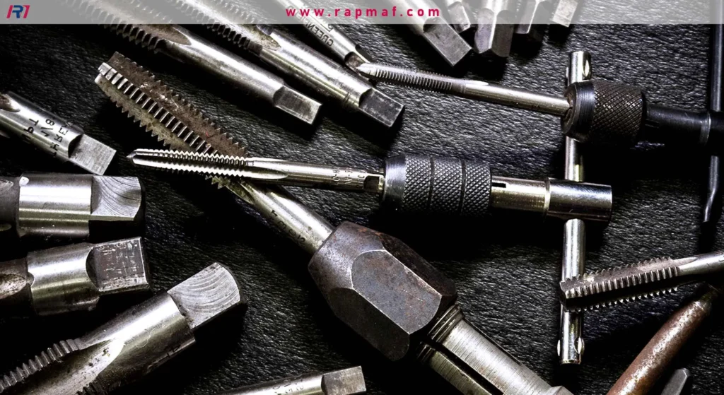 A machinist's collection of high-speed steel (HSS) thread cutting taps, including taper and bottoming taps, organized with tap handles for manual tapping operations.