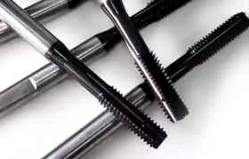 Detailed view of the precision-ground cutting flutes on two new machine taps, designed for creating clean and accurate internal threads in metal parts.