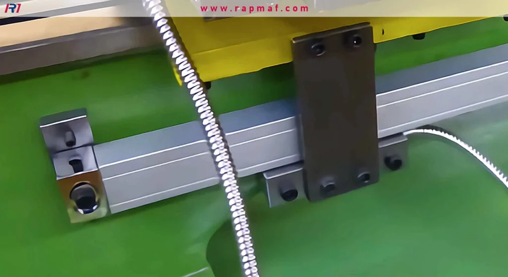 A close-up of a professional optical or magnetic DRO scale mounted onto the bed of a lathe, with the reading head ready to measure the carriage's travel.