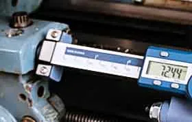 A digital readout display on a hobbyist lathe showing a precise measurement of 7.244 units, demonstrating the accuracy gained by adding a DRO.