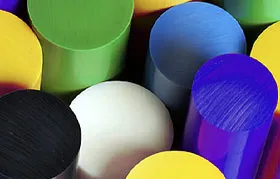 An assortment of raw polymer stock materials in rod form, showcasing the variety of thermoplastics available for CNC machining, where material selection is based on key properties like flexural modulus (rigidity).