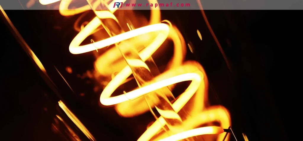 An artistic close-up of a heated tungsten filament, showing its coiled-coil structure which increases its length and light output within a small space. This demonstrates the material science behind incandescent lighting.

