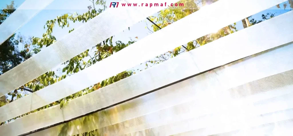 A Rapmaf image showing strips of translucent, woven PET fabric (polyester) hanging outdoors. This demonstrates another common form of Polyethylene Terephthalate, used in textiles and industrial strapping, and highlights its use in applications where it is exposed to environmental factors like sunlight.