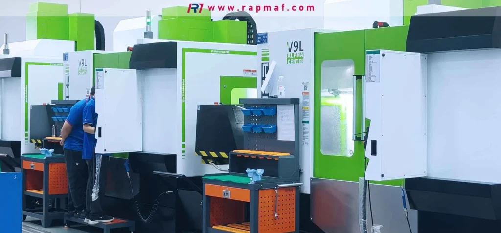 The Rapmaf precision machining workshop, featuring a line of modern Fanuc V9L Alpha Center CNC machines. A technician works at a station, highlighting the advanced manufacturing environment required to produce the high-precision components that enable the AI revolution.