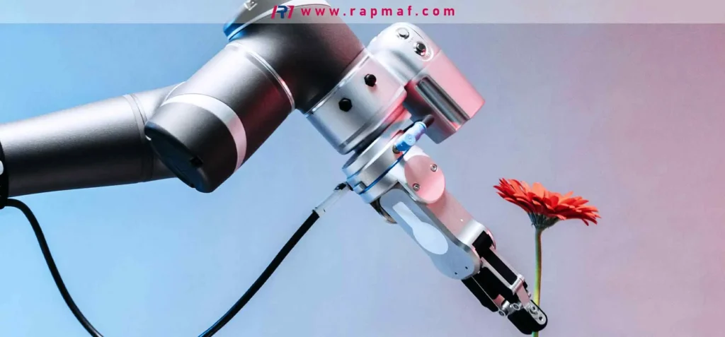 A high-precision, CNC-machined robotic arm, representing the "bones" for an AI system, gently holding a single red gerbera daisy. This image, by Rapmaf, highlights the fusion of advanced manufacturing with delicate, human-like capability.