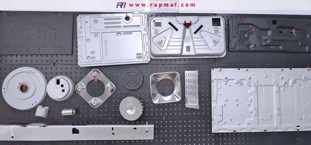 Una exposición de diversas piezas complejas de chapa metálica fabricadas por Rapmaf, incluyendo paneles y carcasas para electrodomésticos. Muchas de estas piezas estampadas, dobladas y conformadas requieren alivio de tensión tras la fabricación para evitar deformaciones y garantizar un ajuste perfecto y enrasado durante el ensamblaje final.