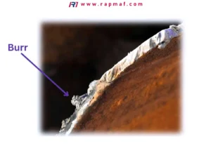 A macro photograph highlighting a critical quality defect: a sharp metal "burr" on the edge of a machined part. This image from Rapmaf's guide emphasizes why going beyond cost to include deburring is essential for the safety and performance of medical device components.