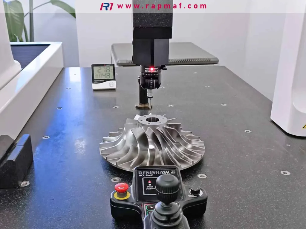 A finished CNC machined impeller undergoing final quality assurance inspection on a Coordinate Measuring Machine (CMM) at the Rapmaf facility, with a Renishaw probe precisely measuring its complex geometry.