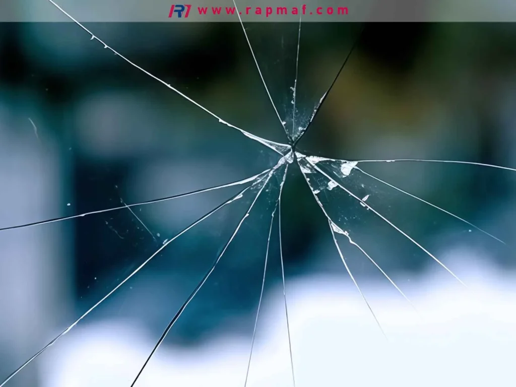 A close-up of a shattered sheet of clear acrylic, demonstrating the material's brittle nature and susceptibility to fracture upon sharp impact, a key consideration for engineering applications.