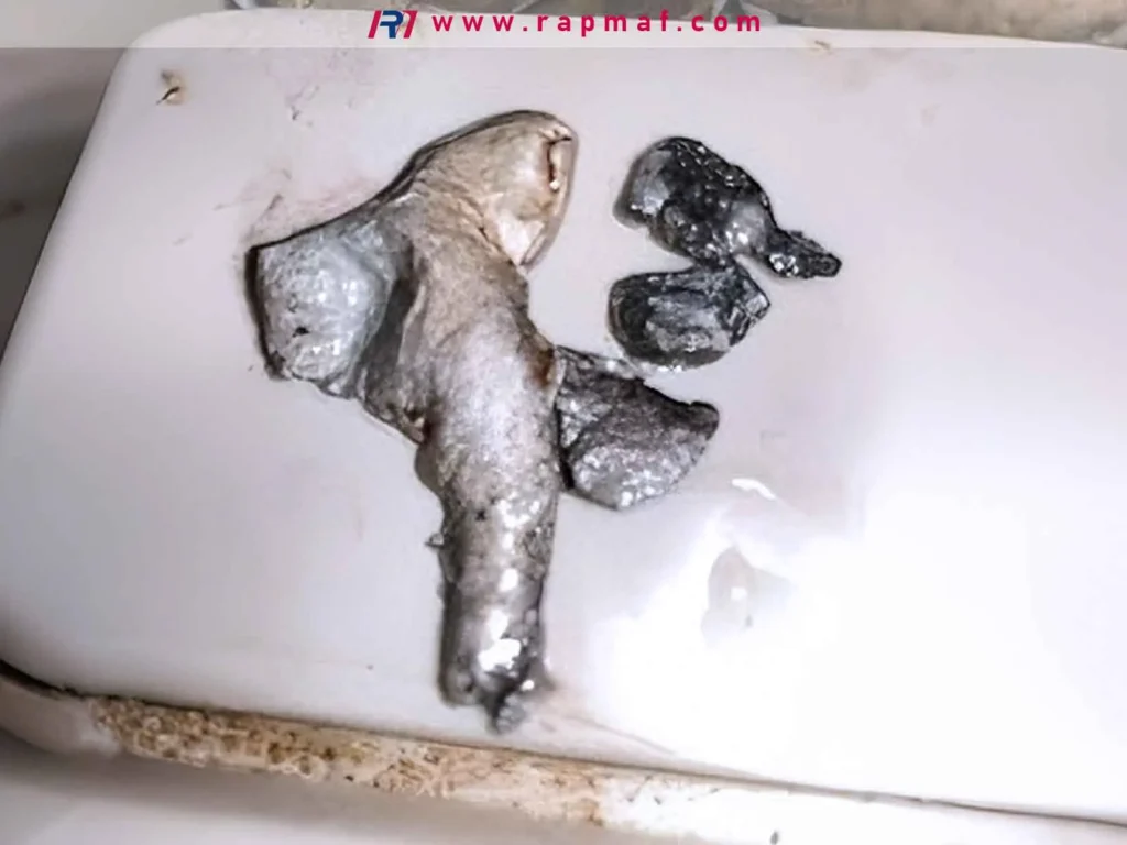 Blobs of metal, likely silver or a low-melting-point alloy, that have been melted and then solidified on a ceramic surface, showing the physical result of reaching a material's melting point.
