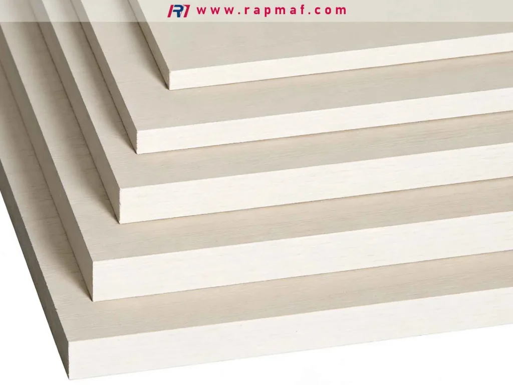 A stack of wood composite sheets of varying thicknesses, illustrating how material type and thickness are key cost drivers for waterjet cutting services.