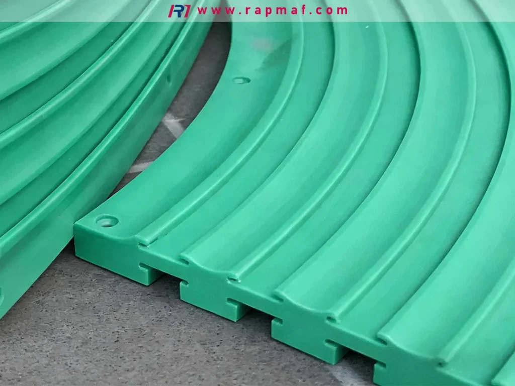 A close-up of a custom green HDPE part, likely a conveyor guide rail, precision machined by a company like Rapmaf to showcase HDPE's excellent machinability and low-friction surface.