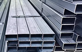 Large bundles of square and rectangular aluminum tubing neatly stacked in a warehouse, representing another common form of raw material used for industrial metal fabrication and CNC machining projects.