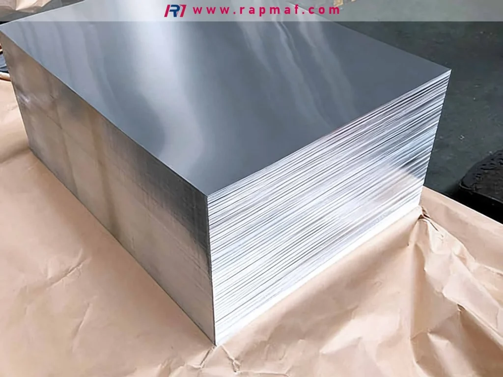 A large, heavy pallet of neatly stacked aluminum sheets in a warehouse setting, illustrating the bulk supply and raw material stock used in industrial fabrication and CNC machining by companies like Rapmaf.