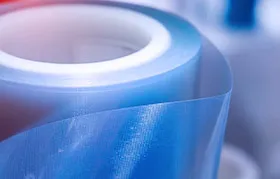 A detailed close-up of a roll of translucent blue polyethylene film, highlighting the material's flexibility and clarity for use in packaging and industrial liners.