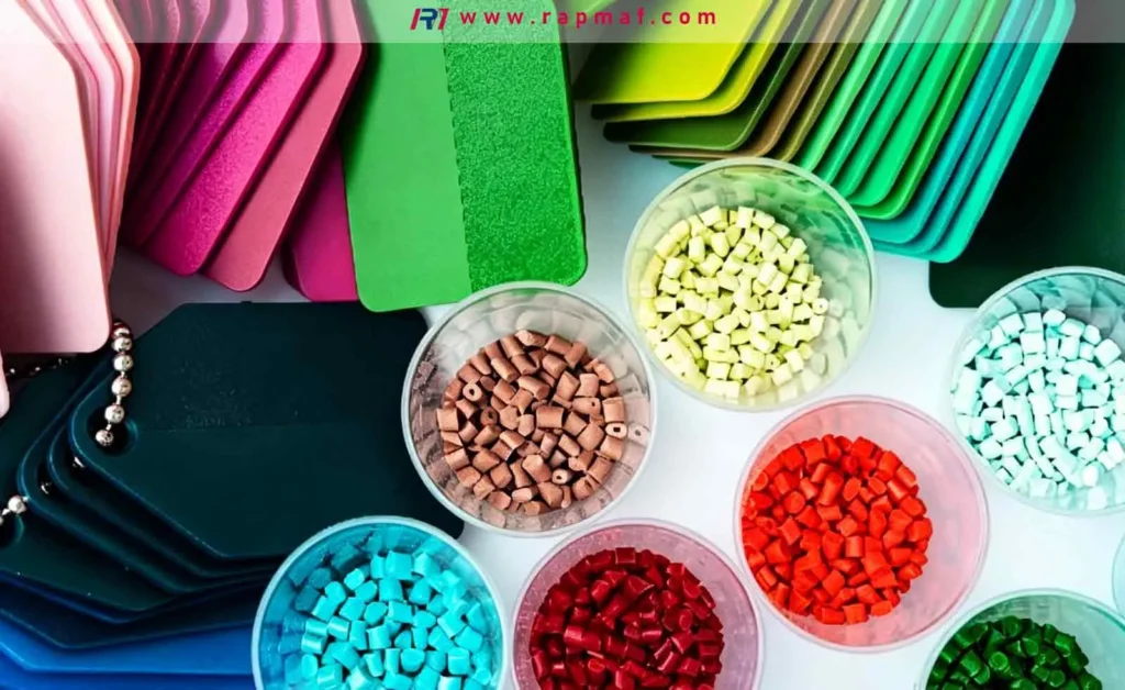 An overhead view from Rapmaf showing colorful polyethylene raw material pellets and plastic color swatch samples, illustrating the range of options for manufacturing custom parts.